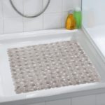 square, plastic shower mat composed of taupe pebble shapes in situ photo on a plain white, square shower tray in a white bathroom