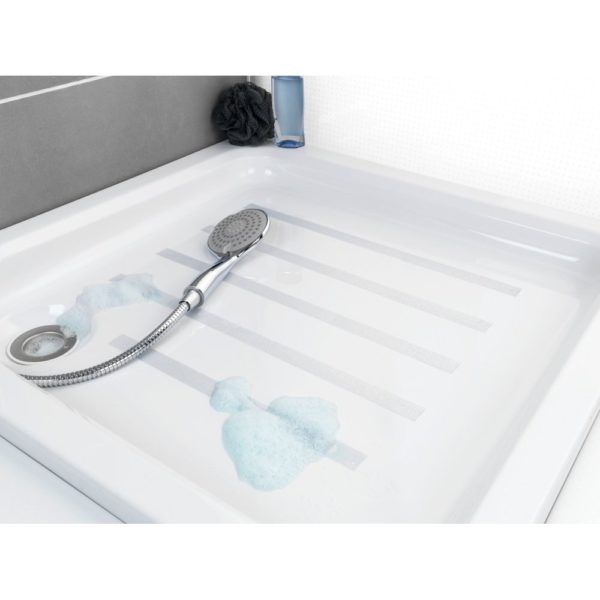 a shower tray with strips of, a shower head transparent anti-slip tape applied in parallel lines, there are also soap bubbles and a shower head placed on the tray.