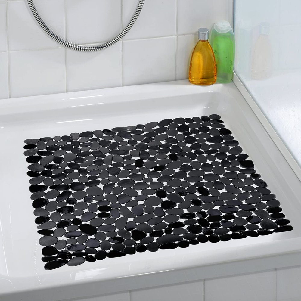 square, plastic shower mat composed of black pebble shapes in situ photo on a plain white, square shower tray in a white bathroom