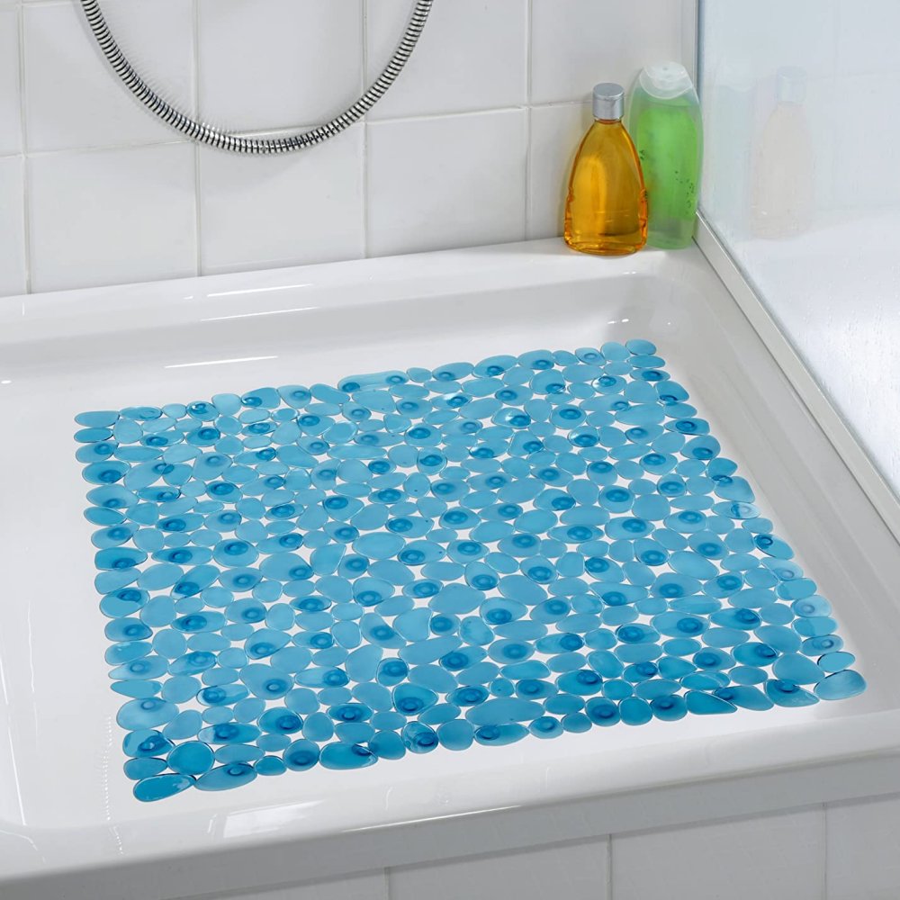 square, plastic shower mat composed of petrol blue pebble shapes in situ photo on a plain white, square shower tray in a white bathroom