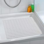 plastic, square shower mat in a slatted design in a close up in situ photo on a plain white, square shower tray in a white bathroom
