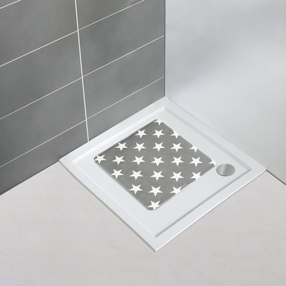 grey square shower mat with a repeating white 5 point star pattern in situ on a plain white, square shower tray in the corner of a bathroom with a white floor and one grey tiled wall and one plain white wall
