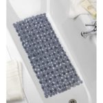 rectangular, plastic bath mat composed of anthracite coloured pebble shapes. It is centred in a white bathtub