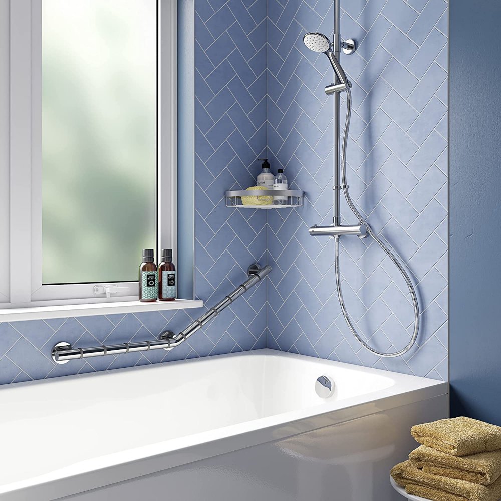 bathroom set up with blue walls and a white bathtub, above this bathtub is a chrome shower on one wall and a large window on the other, between the bath and the window is an angled hand rail to demonstrate a possible position for it