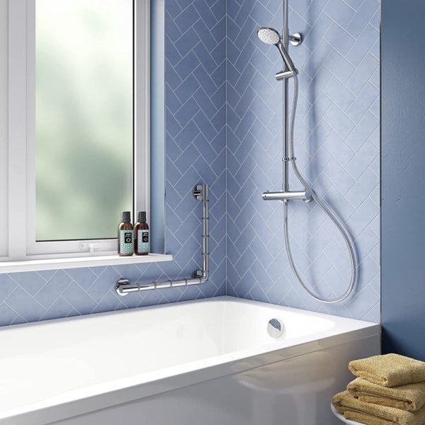 bathroom set up with blue walls and a white bathtub, above this bathtub is a chrome shower on one wall and a large window on the other, a round a lower corner of the window a 90 degree angled hand rail to demonstrate a possible position for it