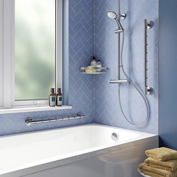 bathroom set up with blue walls and a white bathtub, above this bathtub is a chrome shower on one wall and a large window on the other, to the left of the shower and between the bath and the window are two hand rails to demonstrate possible positions for it