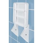 white rectangular shower seat on a blue tiled wall. it is folded in the up position