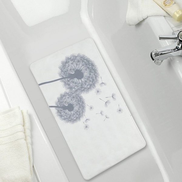 a white, rectangular bath mat with grey silhouettes of two dandelion clocks with a few seeds being scattered it is centred in a white bathtub