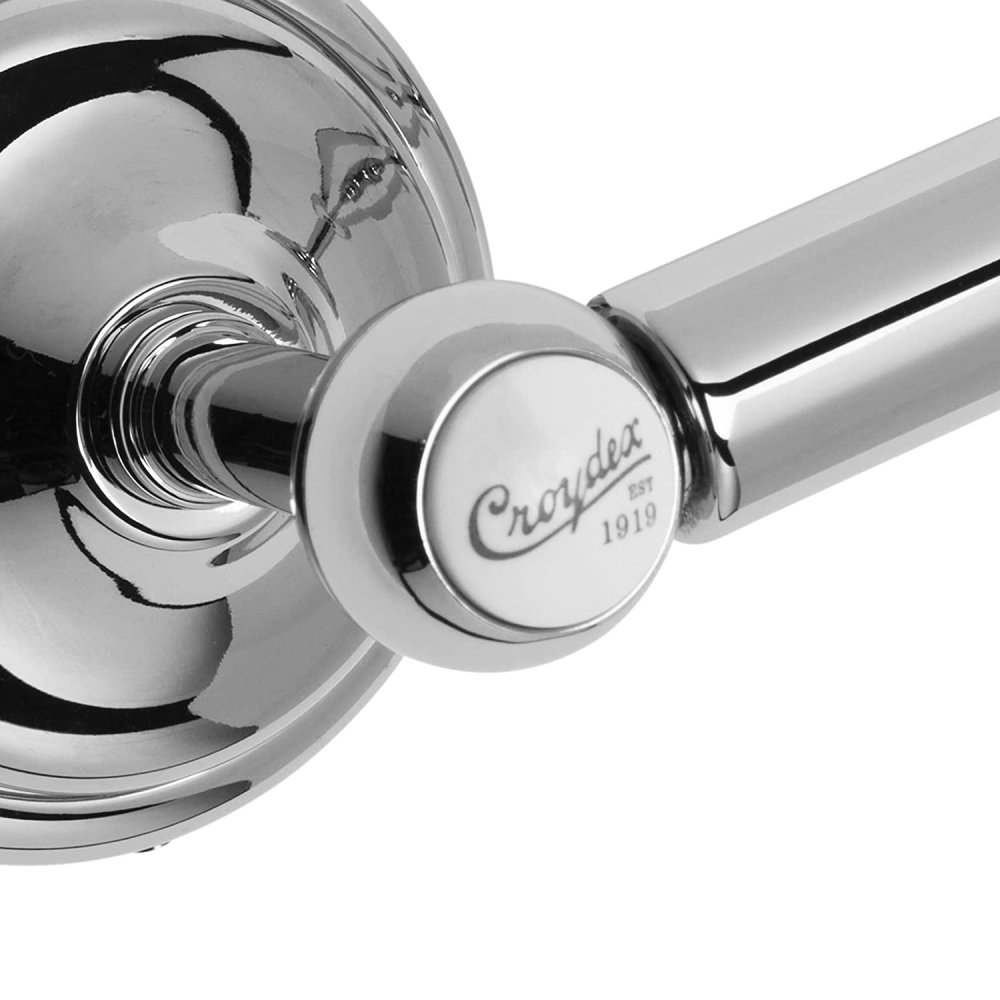 close up of double post spindle toilet roll holder in chrome with two white circles with the text "Croydex est 1919" showing the white circle in more detail