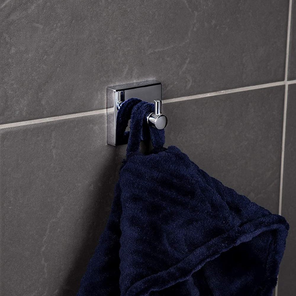 chrome single robe hook with a square back plate, on a grey tiled wall, a dark blue towel is hanging from it