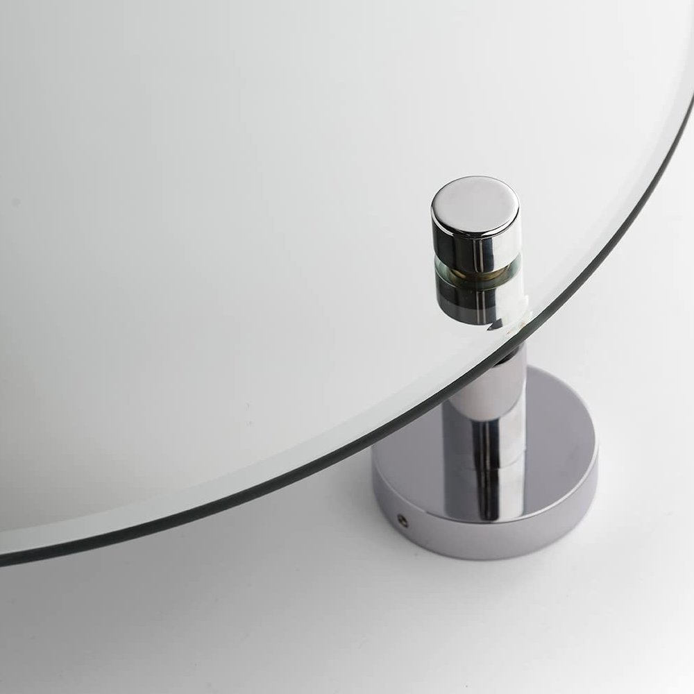 close up of round mirror showing a chrome wall bracket