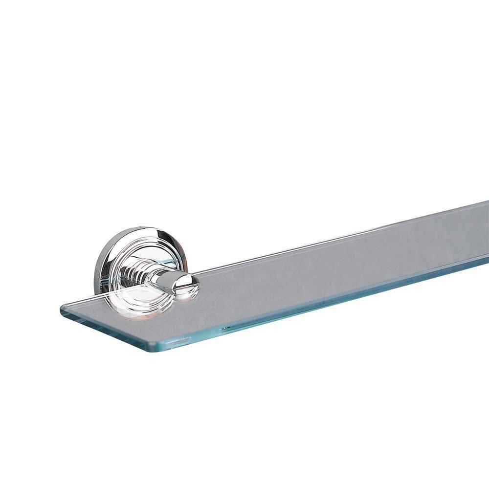 one end of a rectangular, clear glass shelf with a chrome, circular wall plate with an indented circular pattern